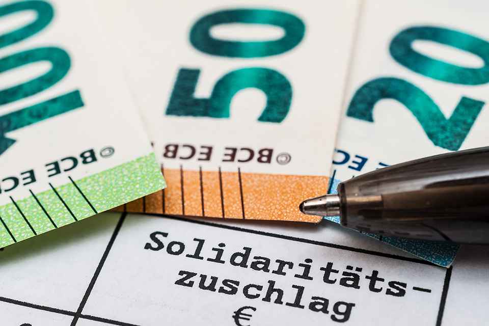 Schriftzug Solidaritätszuschlag und Geldscheine